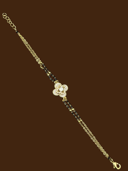 SHE BEAUTY anti-tarnish mangalsutra bracelet featuring a gold-tone chain with black beads and a floral AD stone charm