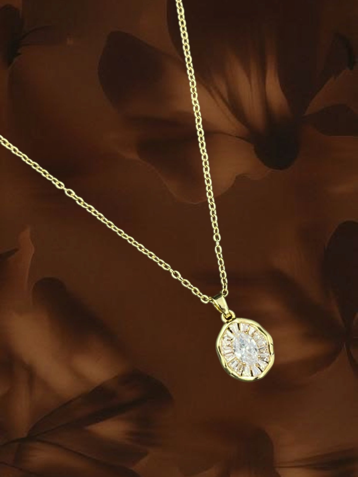 SHE BEAUTY gold medallion pendant necklace featuring a central oval crystal surrounded by baguette stones