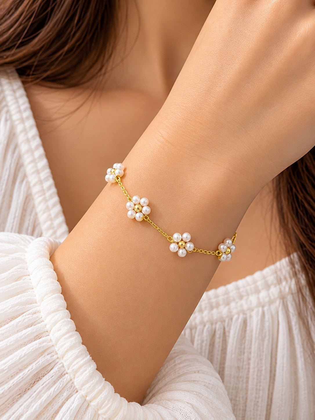 SHE BEAUTY KIYU ZIYU gold chain bracelet featuring delicate white pearl flower charms on a woman's wrist