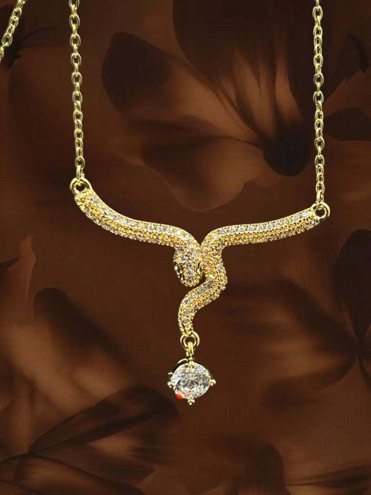 SHE BEAUTY gold-toned serpent pendant necklace featuring sparkling cubic zirconia stones for festive party wear.