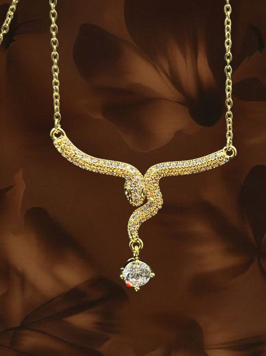 SHE BEAUTY gold-toned serpent pendant necklace featuring sparkling cubic zirconia stones for festive party wear.
