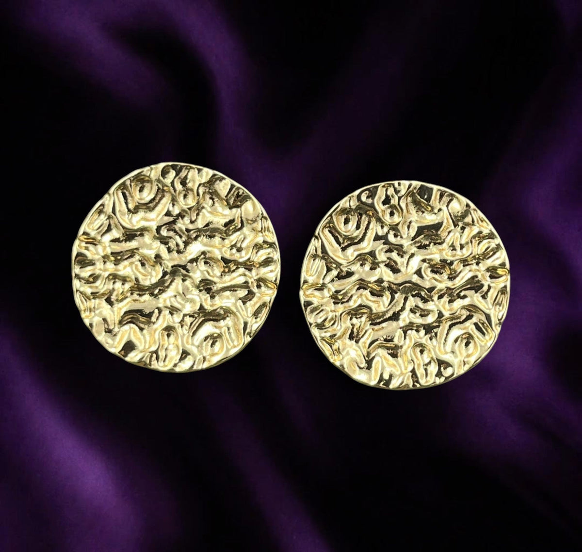 SHE BEAUTY anti-tarnish gold-toned circular stud earrings with a textured hammered finish on a purple silk background