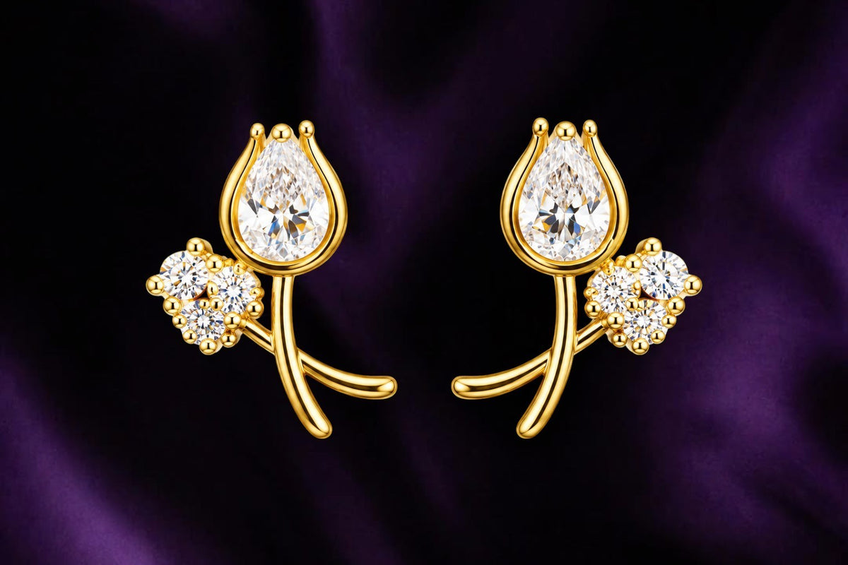 SHE BEAUTY LUXE TULIP STUDS featuring gold-tone metal with pear-shaped and round crystal accents on purple fabric.