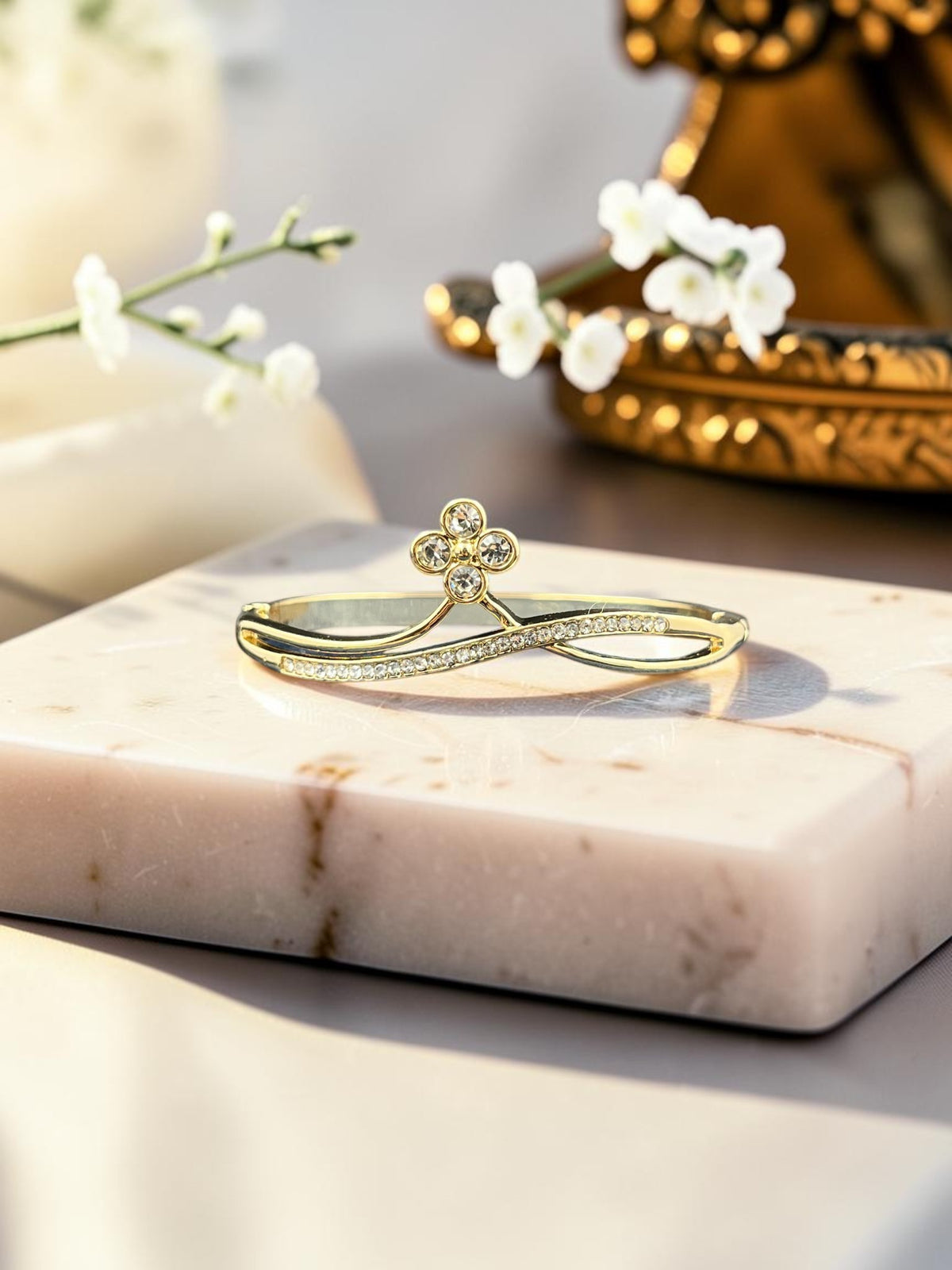 SHE BEAUTY gold-toned anti-tarnish bracelet featuring a delicate flower motif with sparkling zirconia stones.