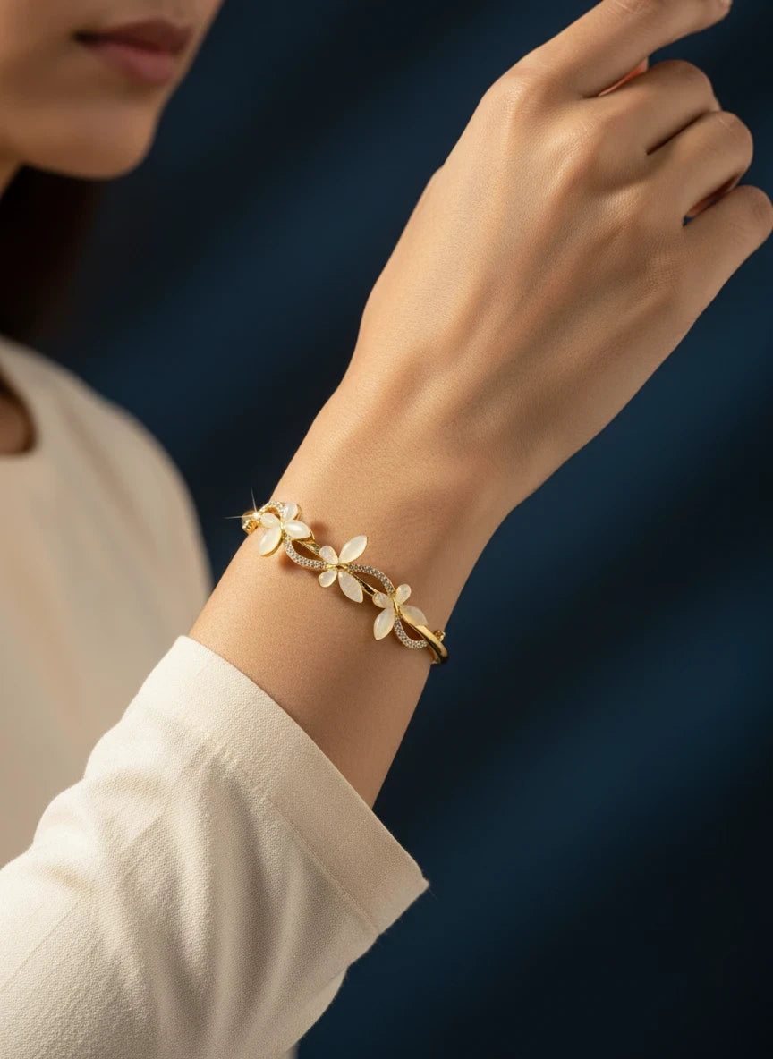 SHE BEAUTY anti-tarnish gold bracelet featuring delicate white flower petals and sparkling zirconia accents on wrist