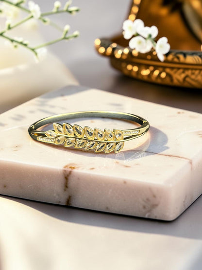 SHE BEAUTY gold-toned anti-tarnish bracelet featuring a leaf-inspired design with sparkling zirconia stones.