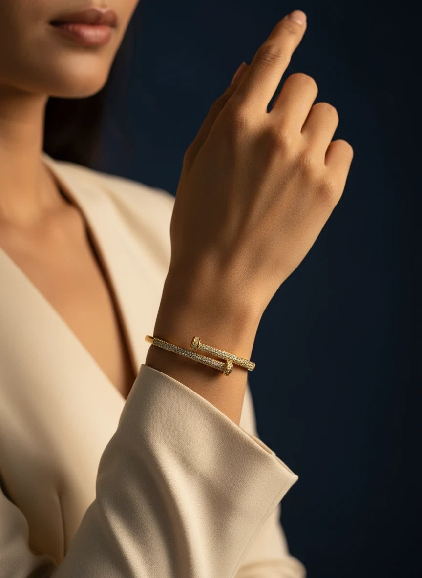SHE BEAUTY gold nail-style bracelet with sparkling zirconia stones worn on a woman's wrist