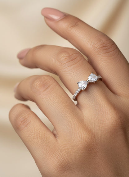 SHE BEAUTY sterling silver ring featuring two heart-shaped cubic zirconia stones on a delicate pavé band