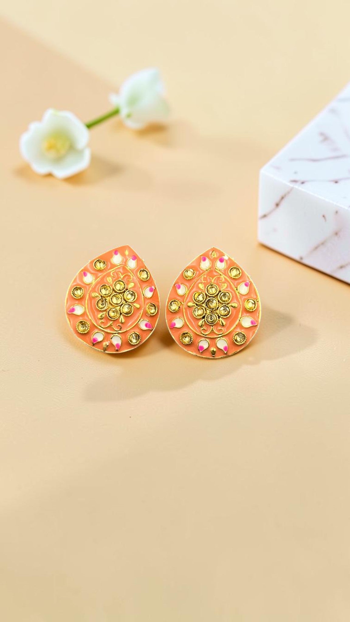 SHE BEAUTY Jaipuri tops featuring peach enamel teardrop studs with intricate gold detailing and floral accents