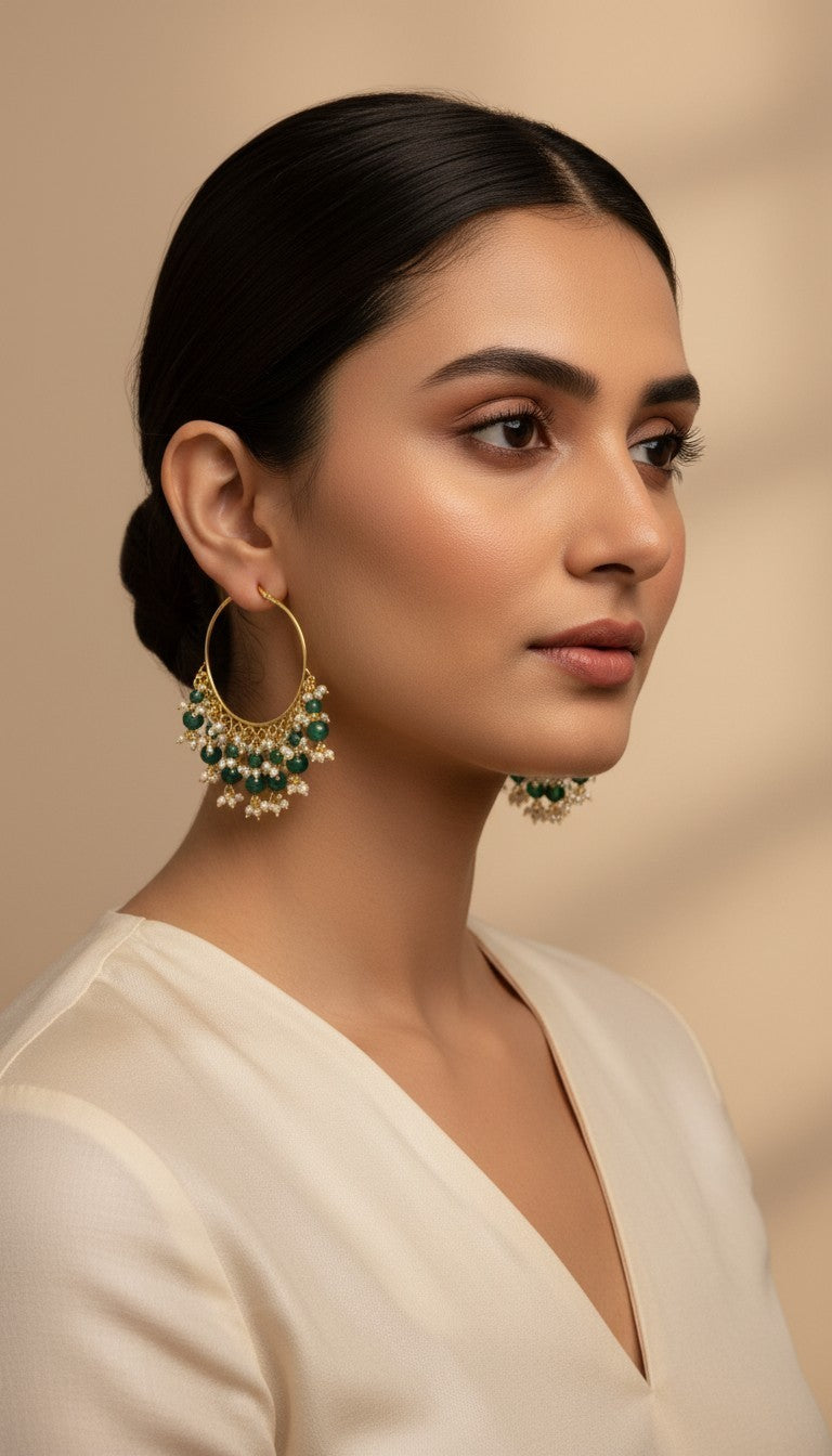 SHE BEAUTY Kashmiri Bali gold hoop earrings featuring green beads and small white pearls worn by a woman