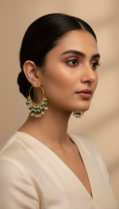 SHE BEAUTY Kashmiri Bali gold hoop earrings featuring green beads and small white pearls worn by a woman