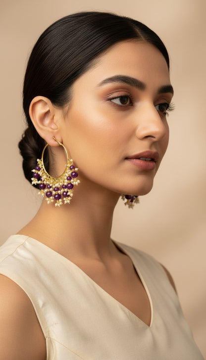 SHE BEAUTY Kashmiri Bali gold hoop earrings with purple beads and small white pearls worn by a woman