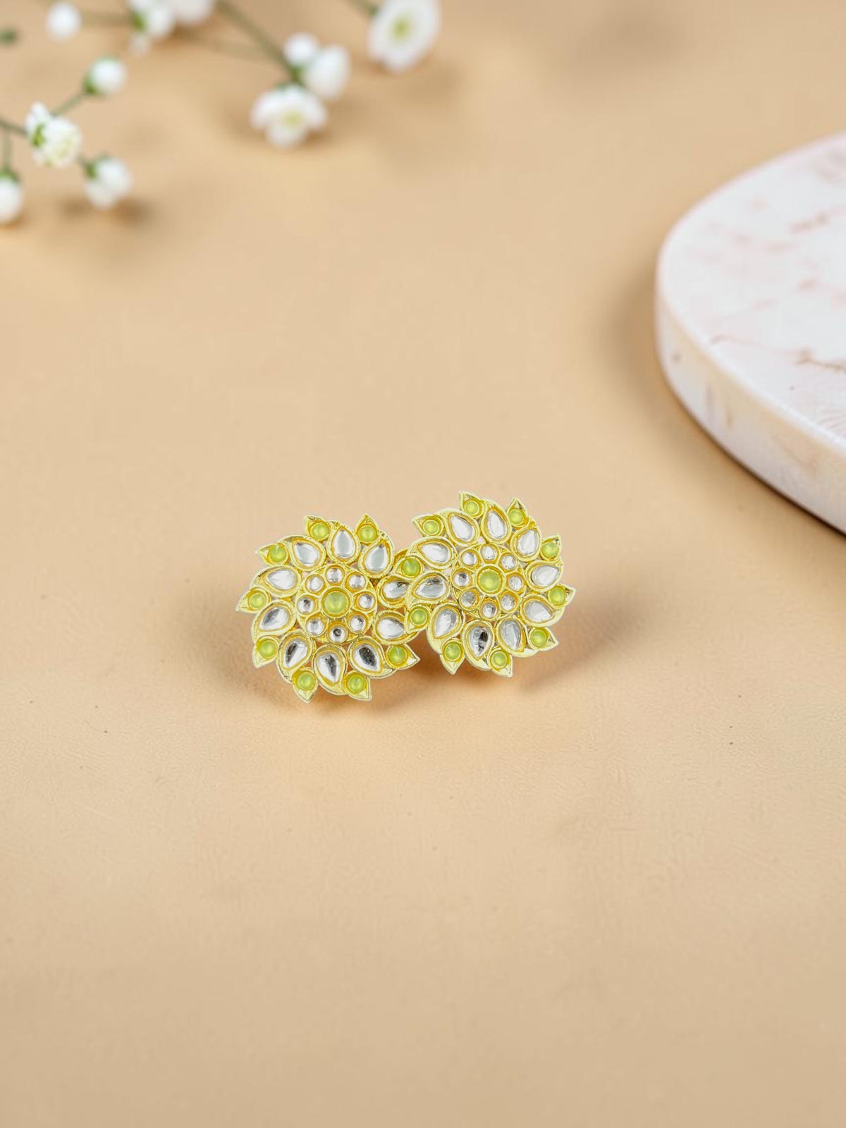 SHE BEAUTY Royal Kundan gold stud earrings featuring a floral design with lime green accents and clear stone detailing.
