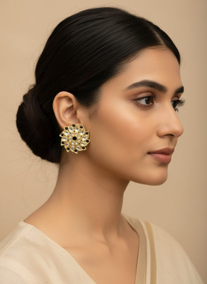 SHE BEAUTY Royal Kundan gold flower-shaped stud earrings with black accents worn by a woman in a side profile view.