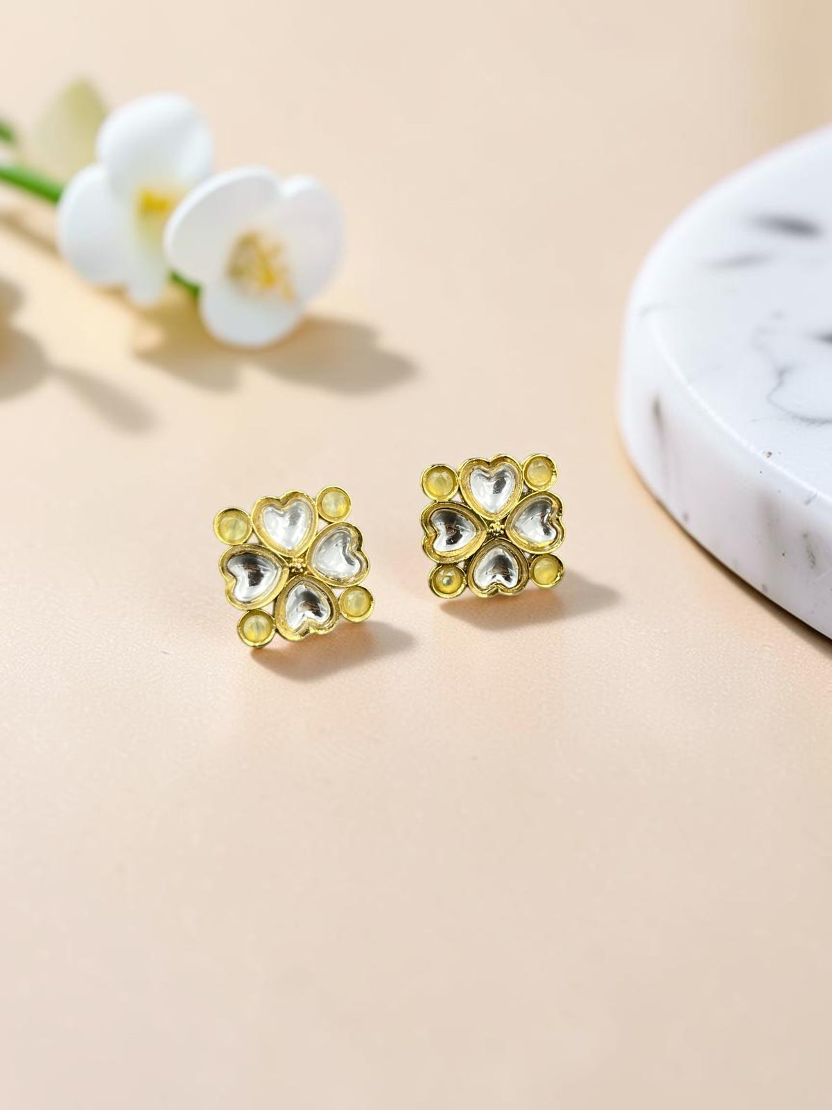 SHE BEAUTY gold-toned kundan stud earrings featuring a delicate four-heart floral design for ethnic and festive wear.
