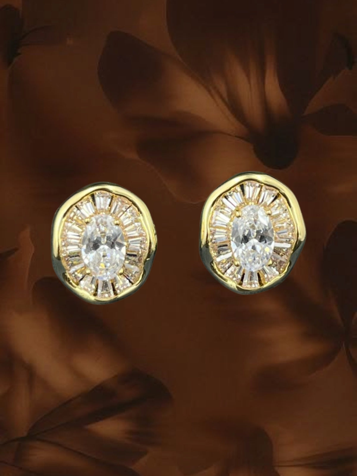 SHE BEAUTY medallion stud earrings featuring a central oval crystal surrounded by baguette stones in gold tone