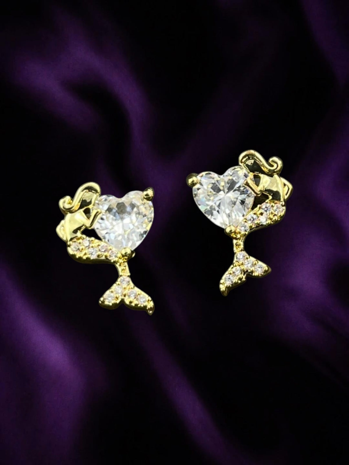 SHE BEAUTY MERMAID HALO gold-tone stud earrings featuring a heart-shaped crystal and mermaid tail design.