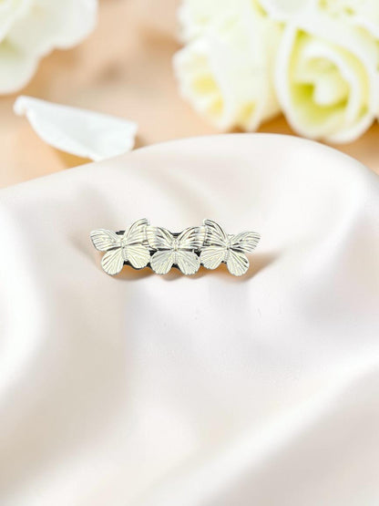 SHE BEAUTY metallic butterfly barrette featuring three silver-toned butterflies on a soft satin fabric background.