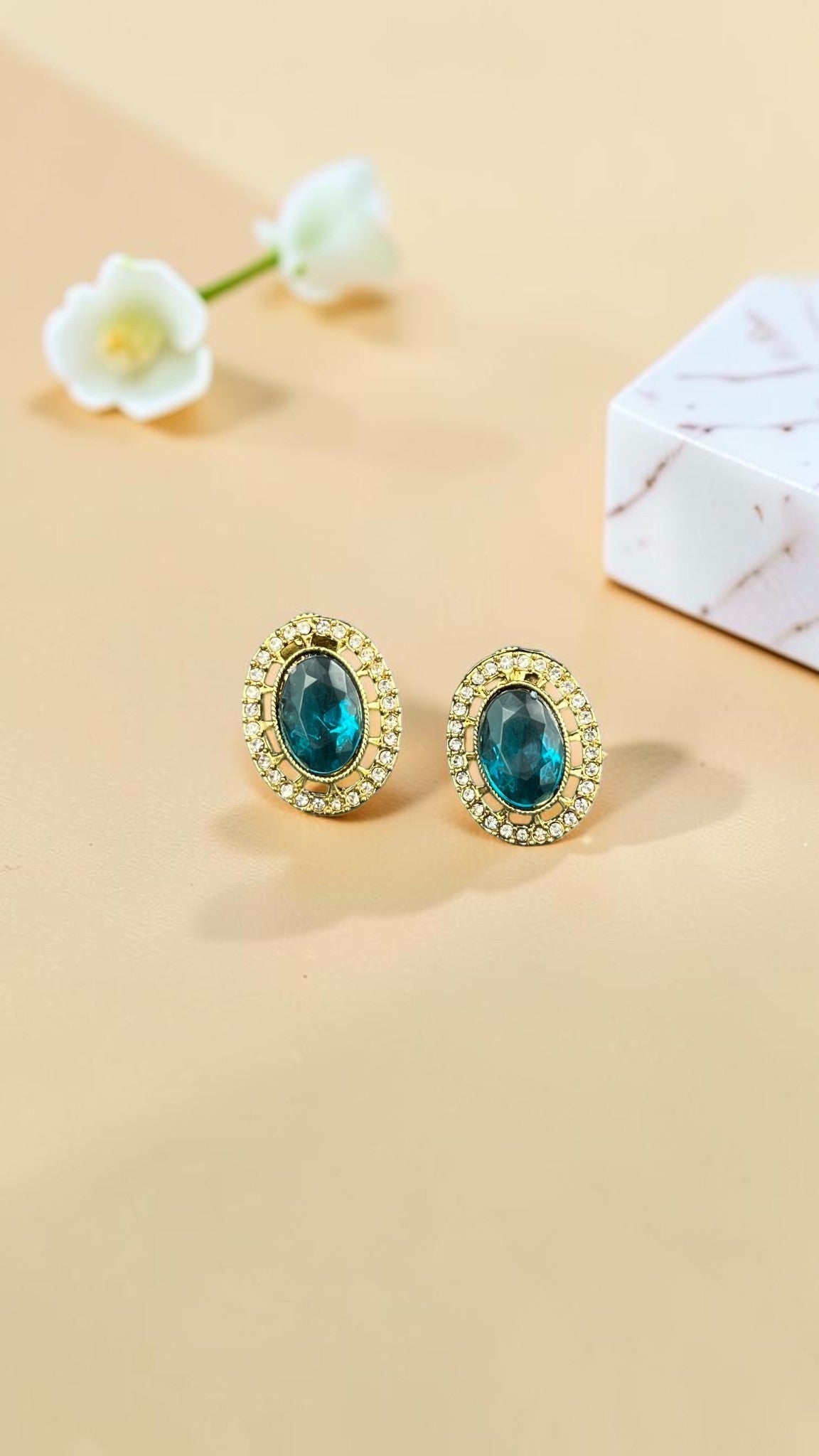 SHE BEAUTY AD antique tops featuring oval teal stones surrounded by sparkling white crystals in a gold-tone setting.