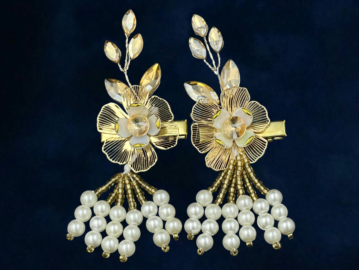 SHE BEAUTY pearl blossom hair clip pair featuring gold metal flowers, crystal leaves, and dangling white pearl beads.