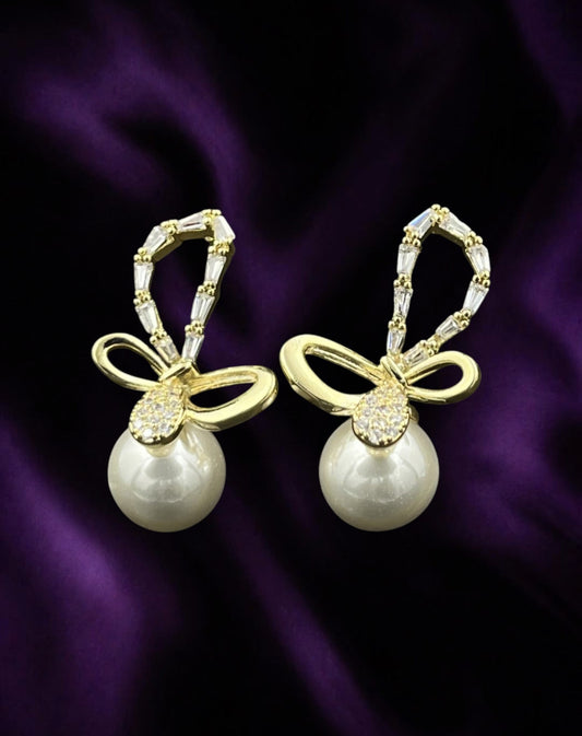 SHE BEAUTY 925 AD pearl earrings featuring gold-tone bow designs with baguette and round cubic zirconia accents.