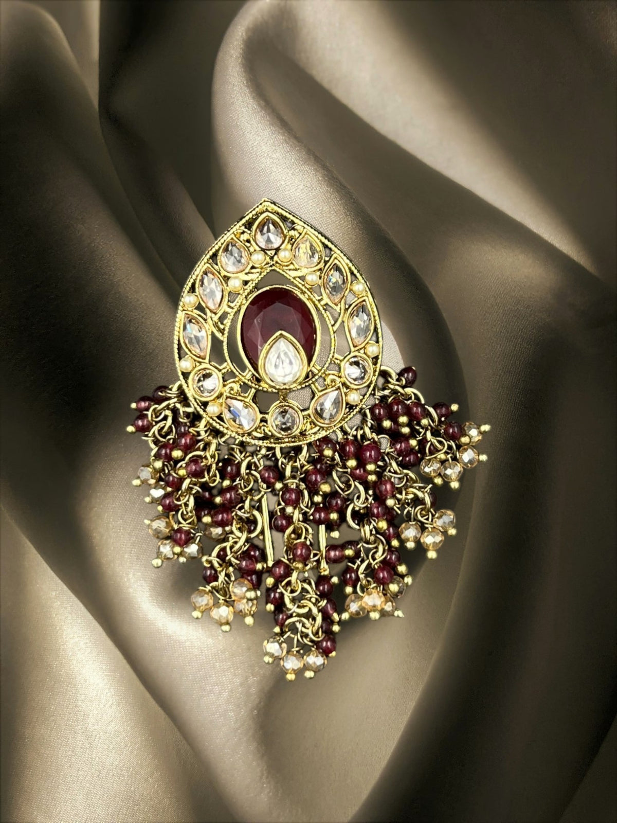 SHE BEAUTY Drop Polki Juda hair brooch featuring a central maroon stone, clear crystals, and dangling beaded tassels.