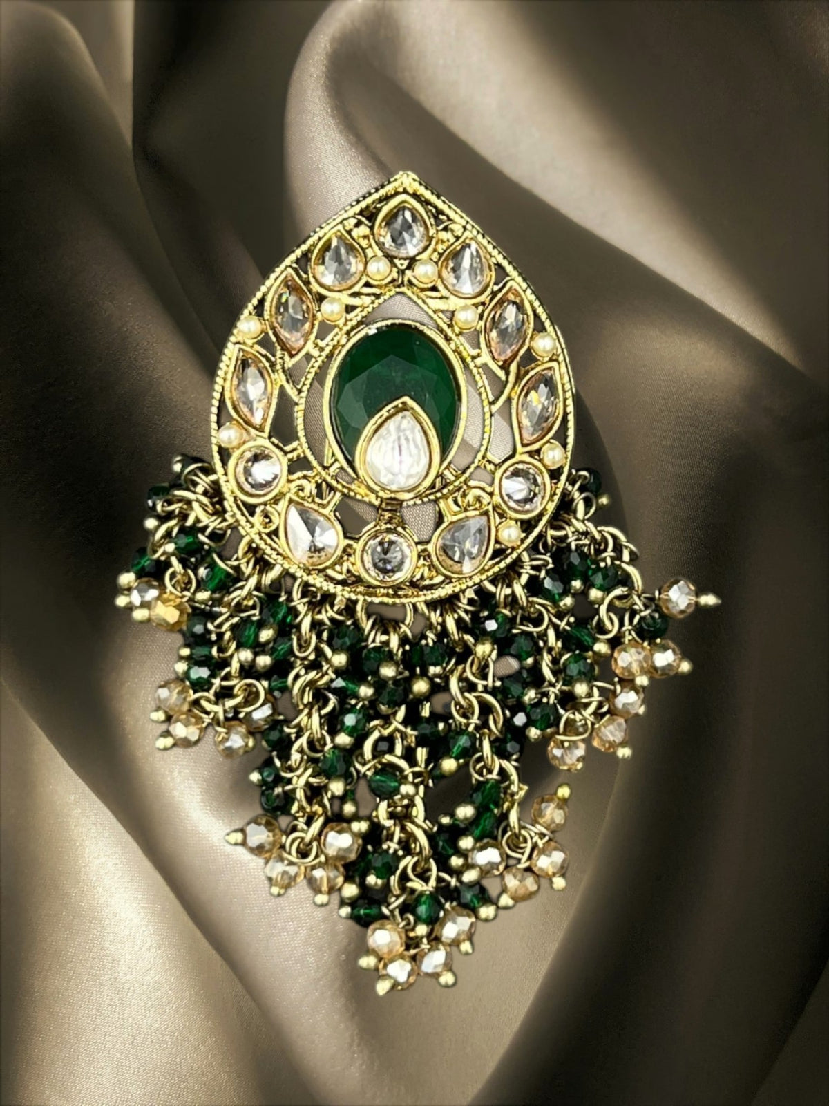 SHE BEAUTY drop polki juda hair brooch featuring a central green stone, clear crystals, and beaded gold-tone tassels.