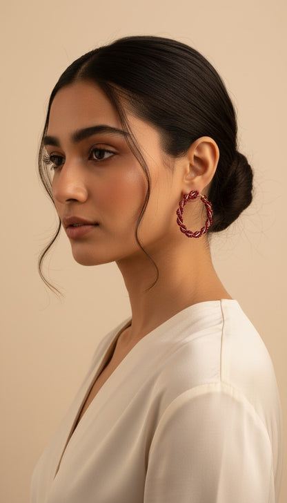 SHE BEAUTY Girlish Crystal Bali hoop earrings featuring a twisted design with deep red crystals on a model