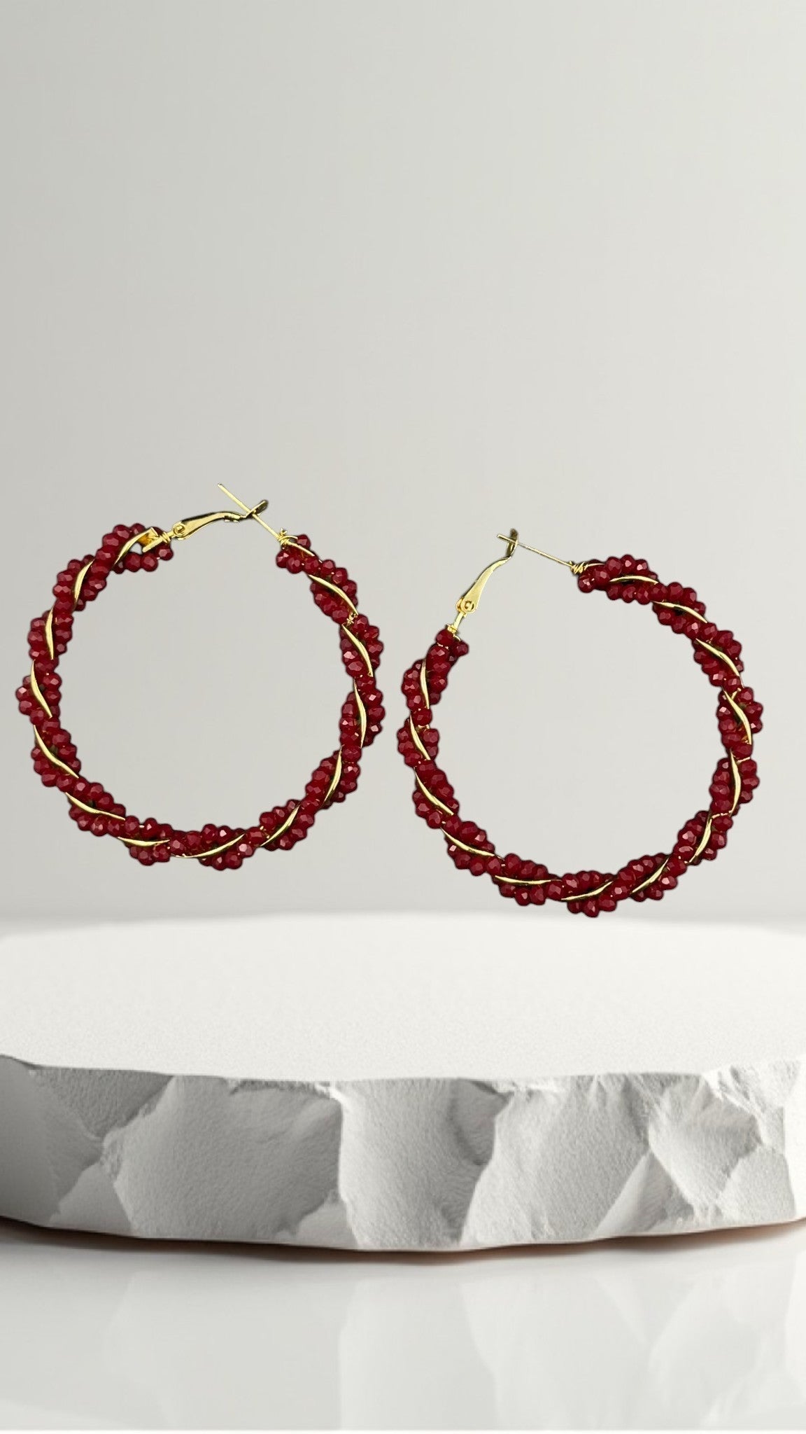 SHE BEAUTY Girlish Crystal Bali hoop earrings featuring twisted red crystal beads wrapped around a gold metal frame.