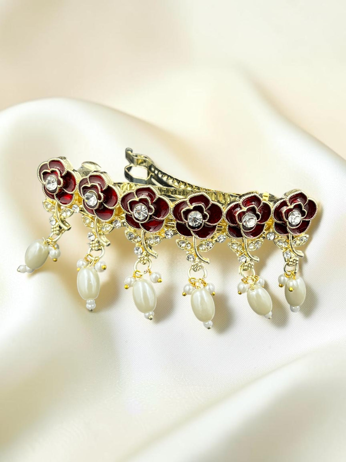 SHE BEAUTY AD rose meenakari barrette featuring red floral enamel, crystal accents, and dangling pearl drops.