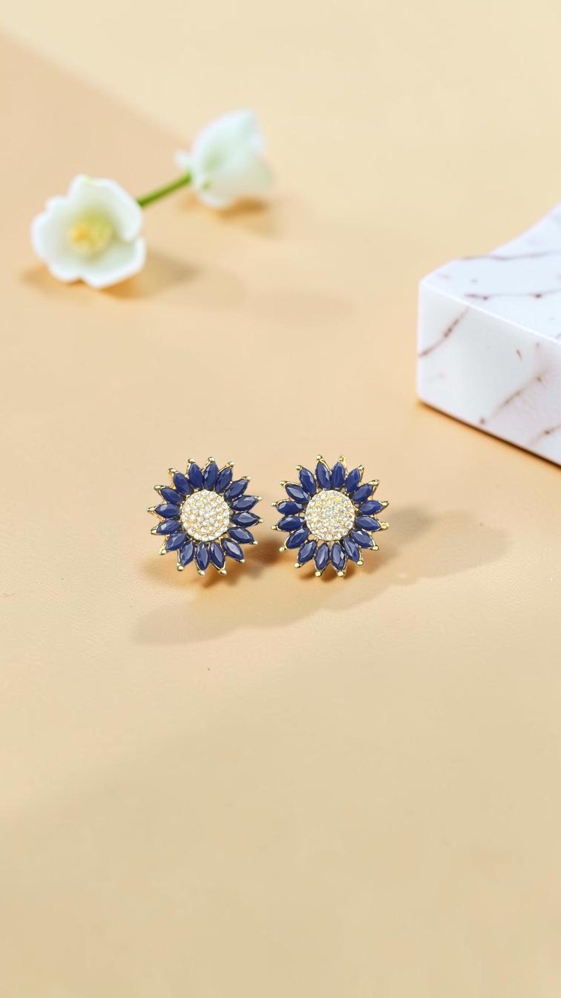 SHE BEAUTY rose gold flower-shaped stud earrings featuring deep blue marquise stones and a sparkling crystal center