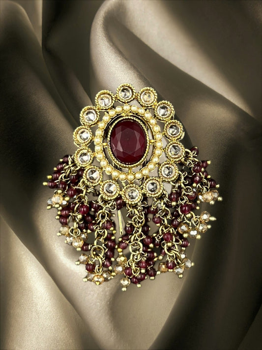 SHE BEAUTY round polki juda hair brooch with a central maroon stone, pearl accents, and dangling maroon bead tassels.