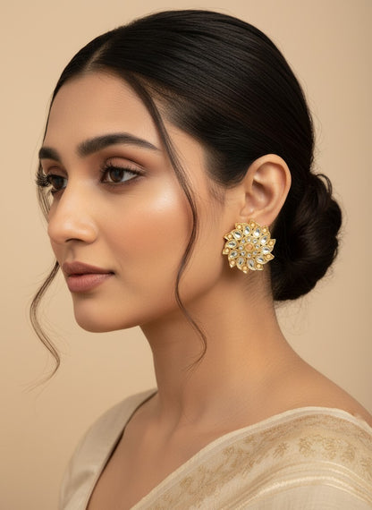 SHE BEAUTY Royal Kundan gold flower-shaped stud earrings worn by a woman with a sleek bun hairstyle