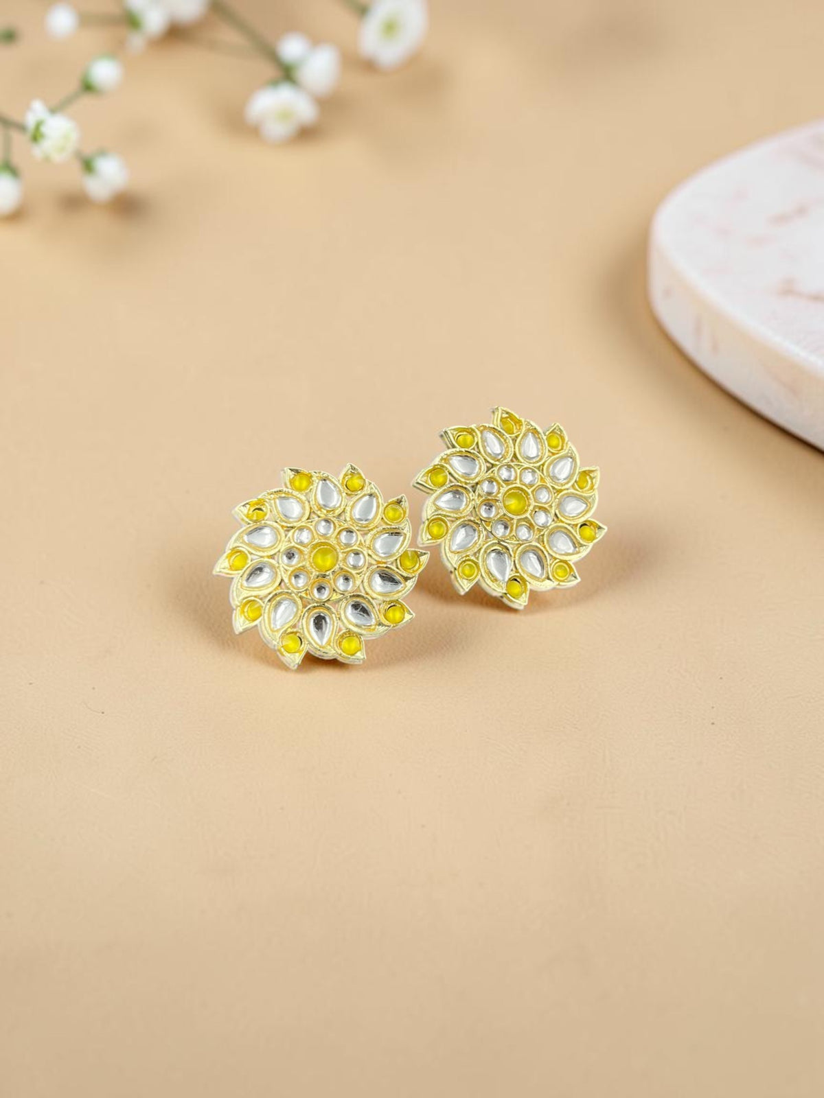 SHE BEAUTY Royal Kundan gold stud earrings featuring a floral design with yellow accents and clear stone detailing.