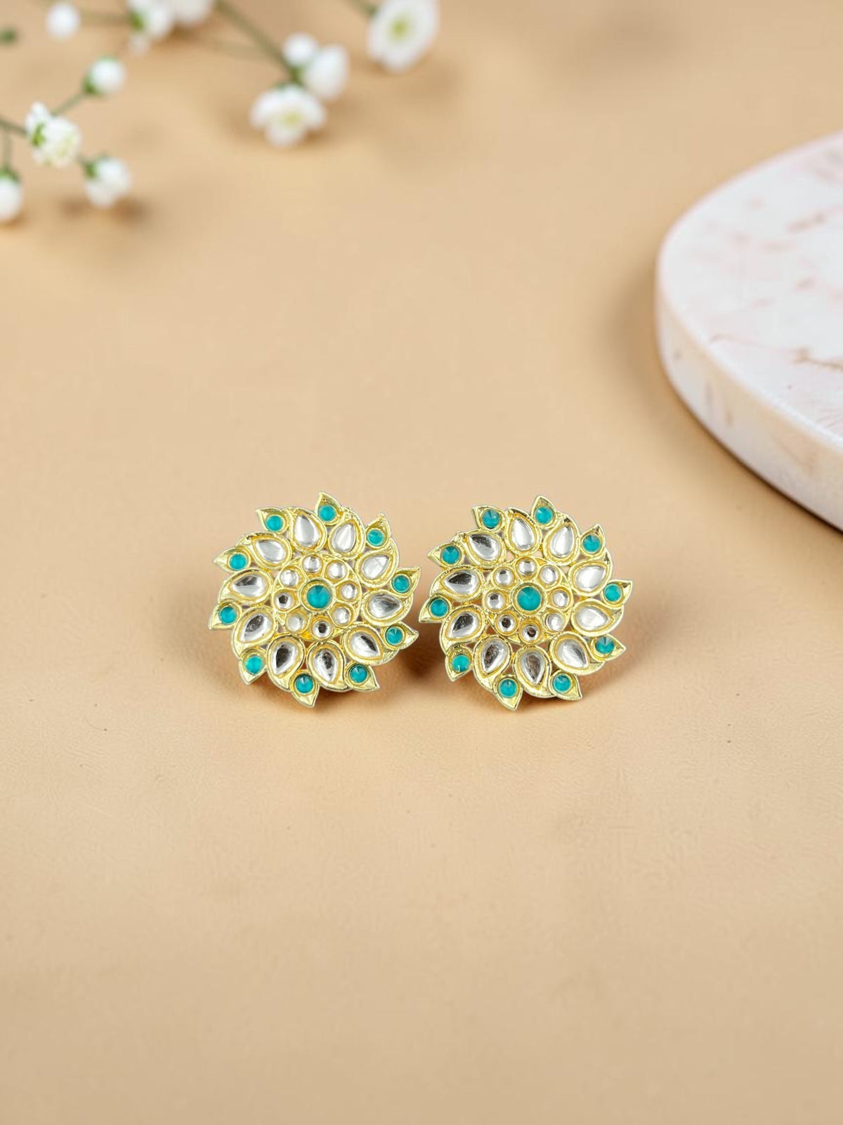 SHE BEAUTY Royal Kundan gold stud earrings with floral design, featuring white stones and teal accents.