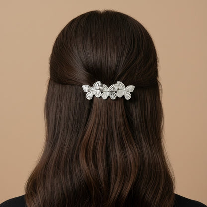 SHE BEAUTY metallic silver butterfly barrette worn in long dark hair for a festive or everyday hairstyle