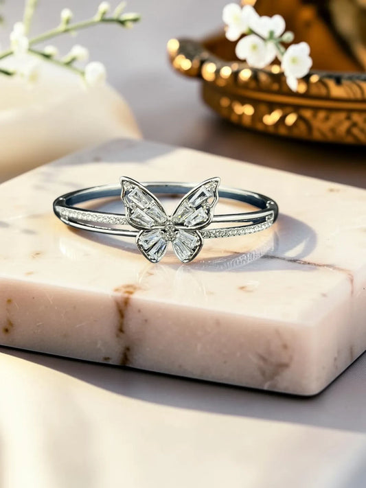 SHE BEAUTY silver anti-tarnish bracelet featuring a sparkling zirconia butterfly centerpiece on a marble display