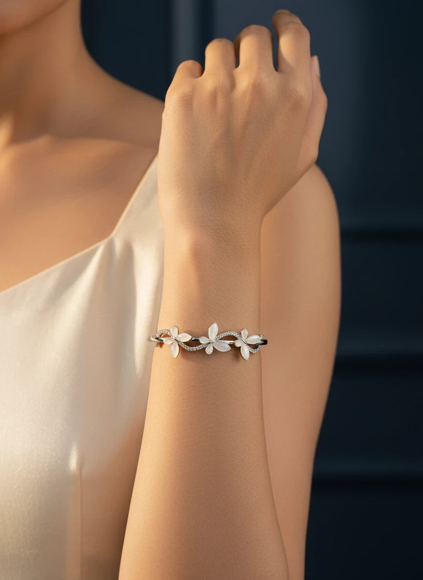 SHE BEAUTY anti-tarnish silver bracelet featuring delicate white floral zirconia accents on a woman's wrist
