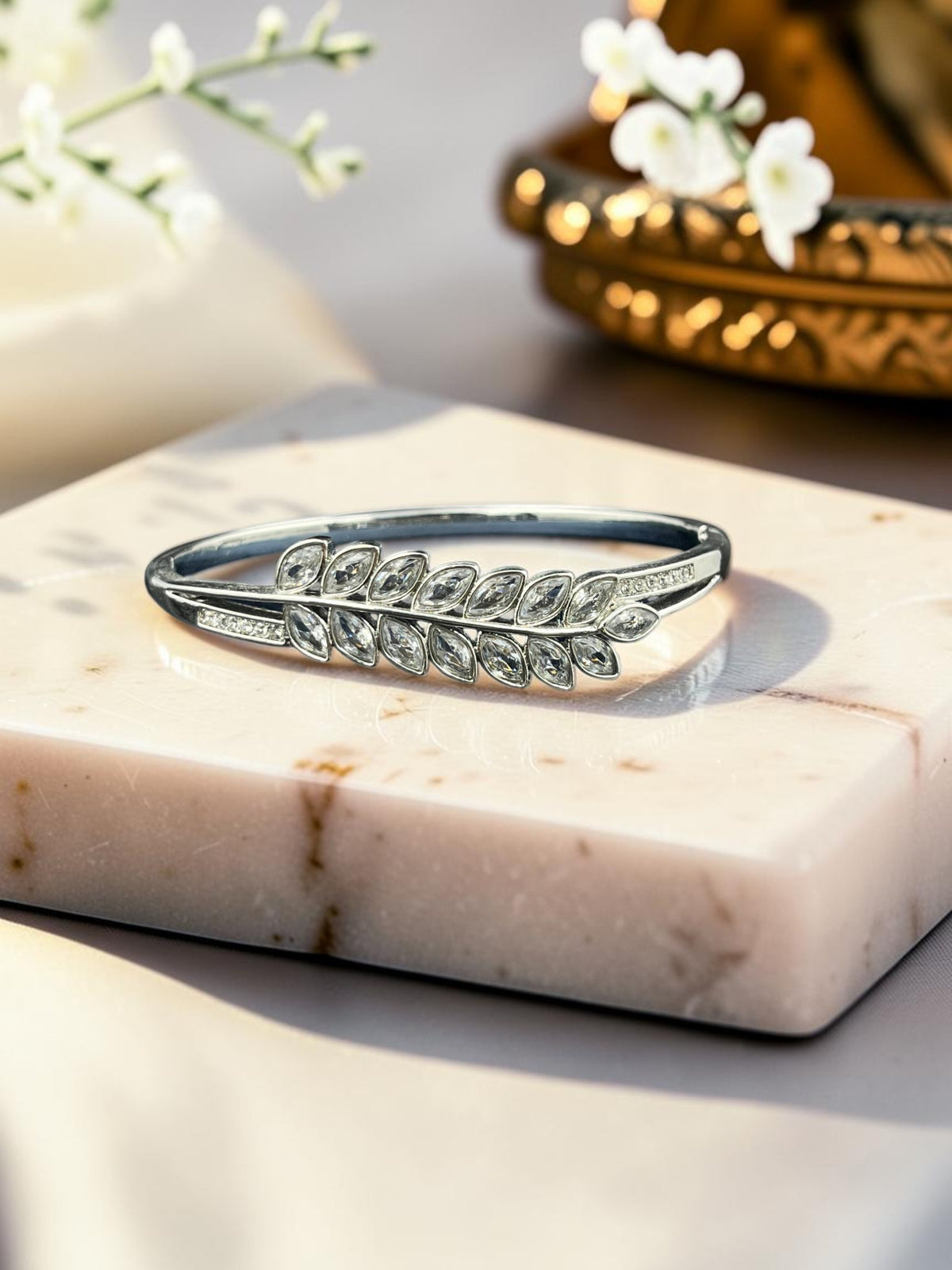 SHE BEAUTY anti-tarnish silver bracelet featuring a marquise-cut zirconia leaf design on a marble display stand.