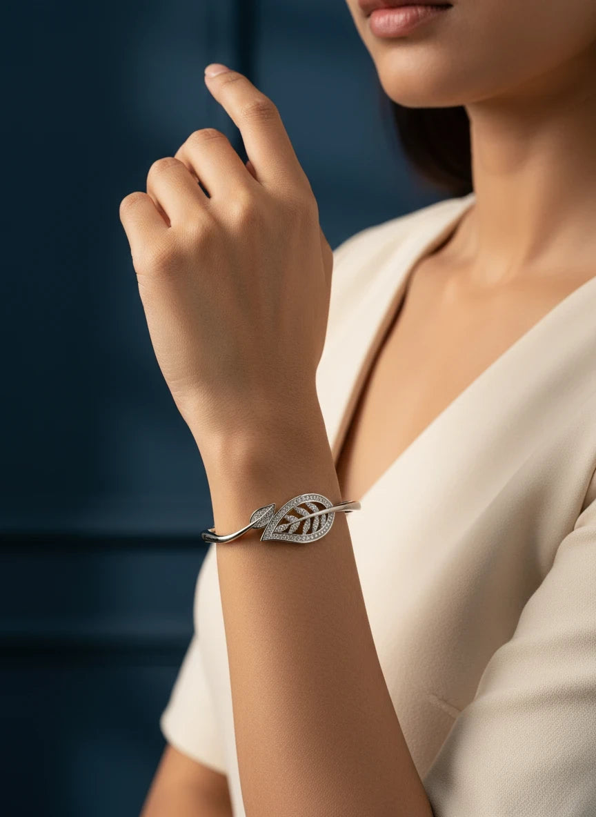 SHE BEAUTY silver-toned zirconia bracelet featuring a delicate leaf design worn on a woman's wrist