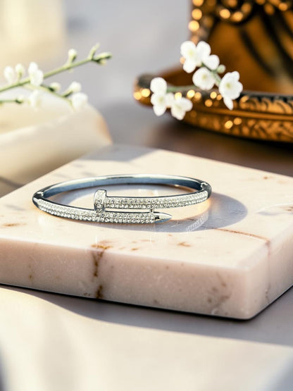 SHE BEAUTY anti-tarnish silver nail-style bracelet featuring sparkling zirconia stones on a marble display stand.