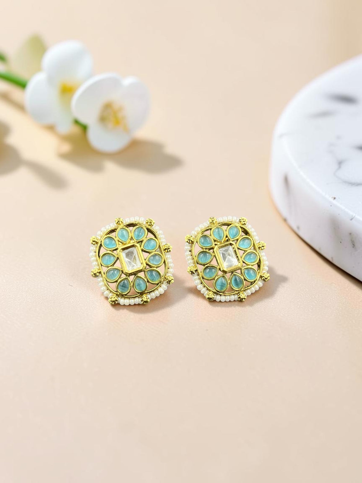 SHE BEAUTY square kundan tops featuring central white stones surrounded by teal accents and delicate pearl detailing.
