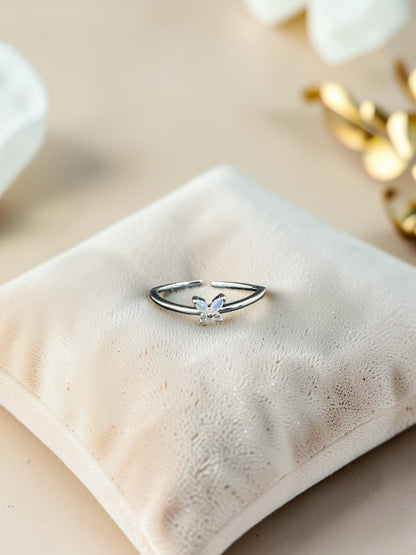 SHE BEAUTY sterling silver adjustable ring featuring a delicate butterfly charm with a shimmering opal-like stone.