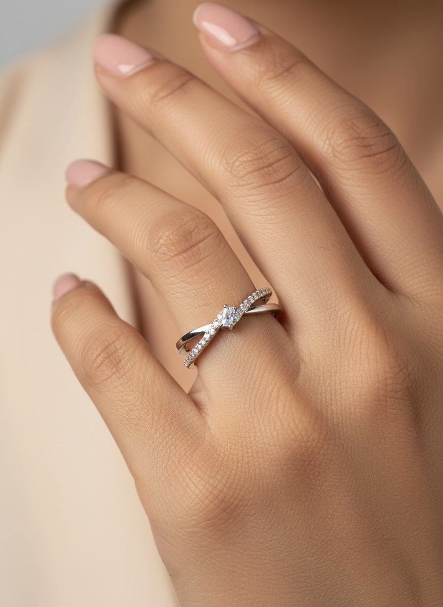 SHE BEAUTY sterling silver crossover ring with a central cubic zirconia stone worn on a woman's finger