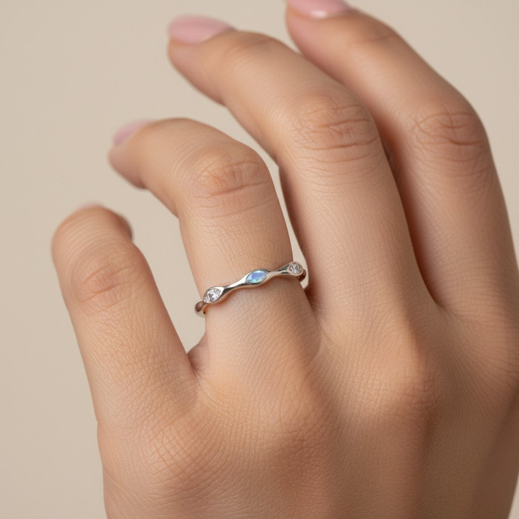 SHE BEAUTY sterling girlish ring with a delicate wavy band, opal stone, and small clear crystals on a hand