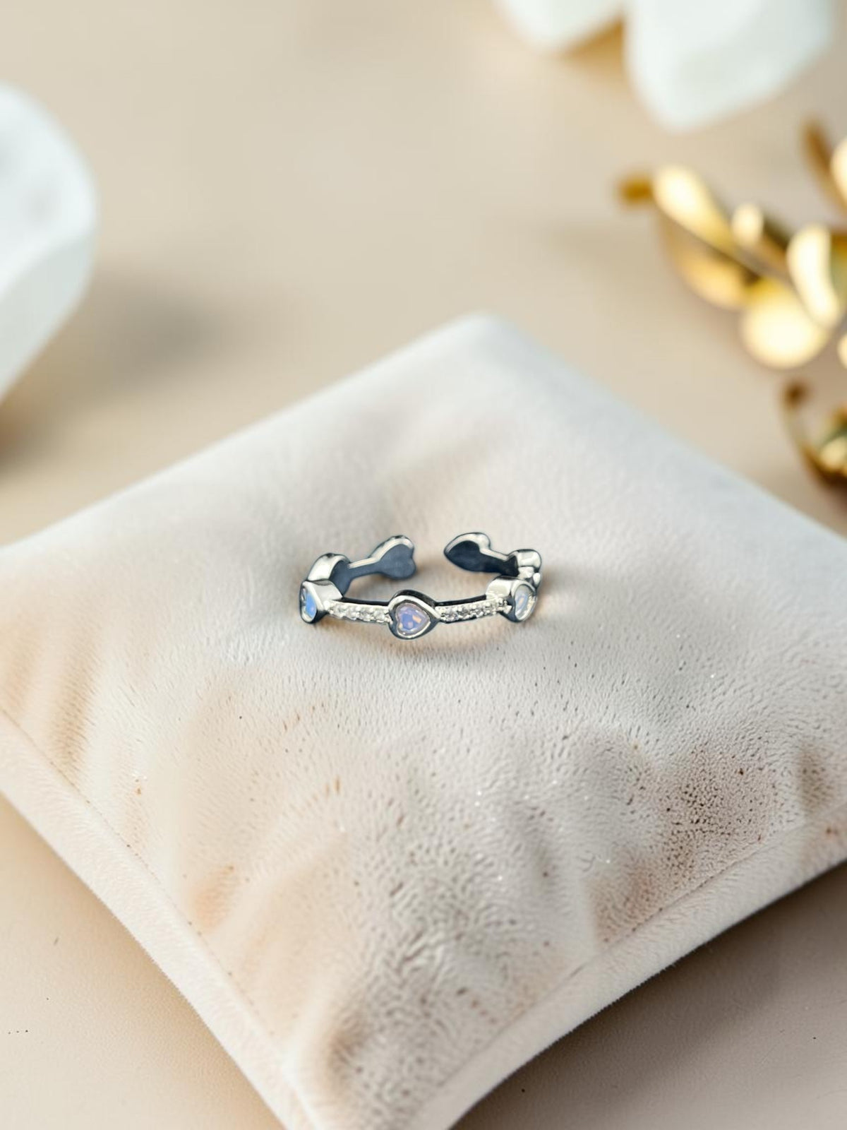 SHE BEAUTY sterling silver girlish ring with heart-shaped moonstone accents on a soft velvet cushion