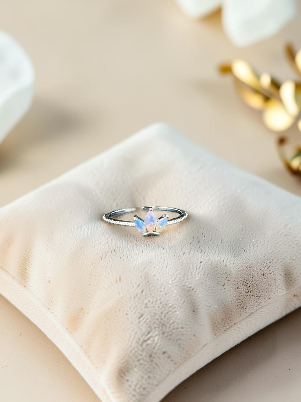 SHE BEAUTY sterling girlish ring featuring a delicate crown design with an iridescent opal stone on a velvet cushion