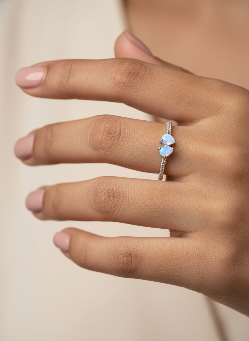 SHE BEAUTY sterling silver girlish ring featuring two delicate pear-shaped opal stones on a sparkling pavé band.