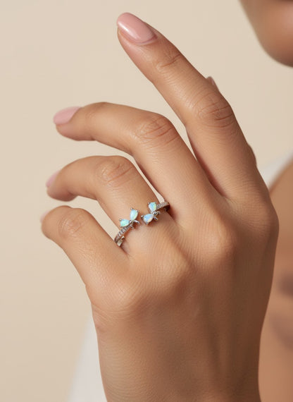 SHE BEAUTY sterling silver open ring featuring delicate butterfly-shaped opal stones on a woman's finger