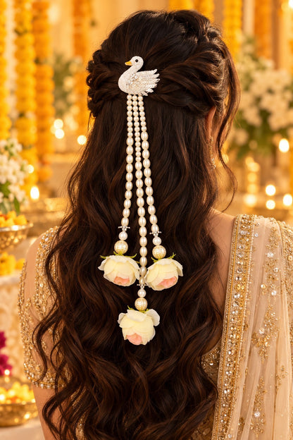 SHE BEAUTY swan hair accessory with white pearls and soft pink rose embellishments worn on long wavy brown hair